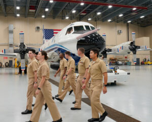 NOAA Commissioned Officer Corps pilots walk through the hangar during their tour of the NOAA Aircraft Operations Center in Lakeland, Florida.
