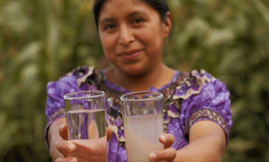 Guatemalteca muestra dos recipientes con agua. 