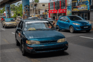 Carro público transportando pasajeros por la avenida Hermanas Mirabal, una de las rutas más transitadas en Santo Domingo Norte.