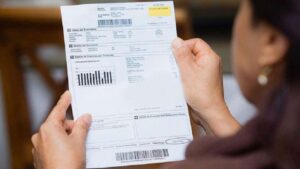Una usuaria revisa detenidamente su factura eléctrica.