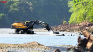 Camiones extraen arena y grava del cauce de un río